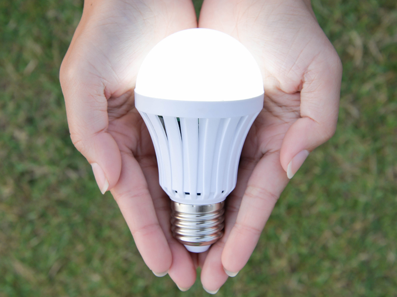 Unas manos sotienen una bombilla encendida