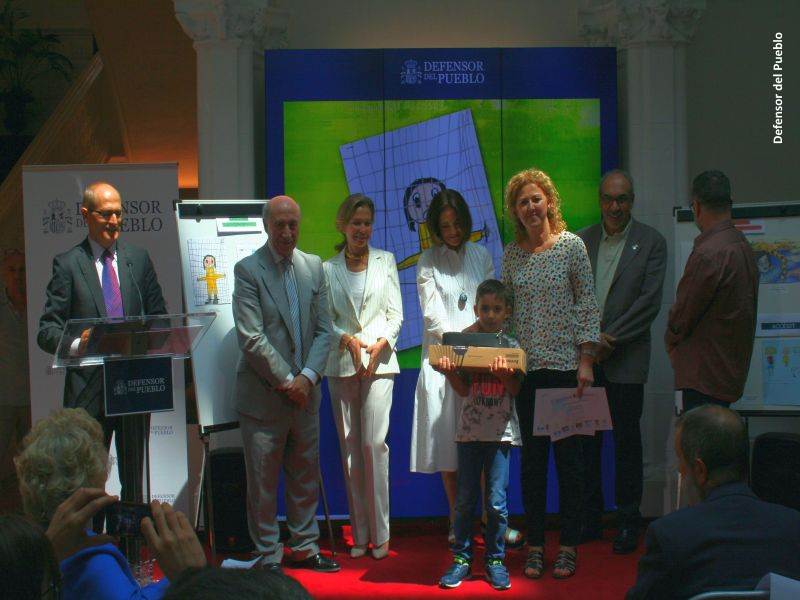 Uno de los ganadores recoge su premio ante la mirada del jurado del Concurso de Dibujos