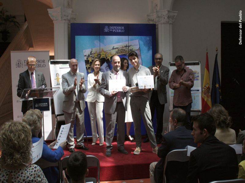 Uno de los ganadores recoge su premio ante la mirada del jurado del Concurso de Dibujos