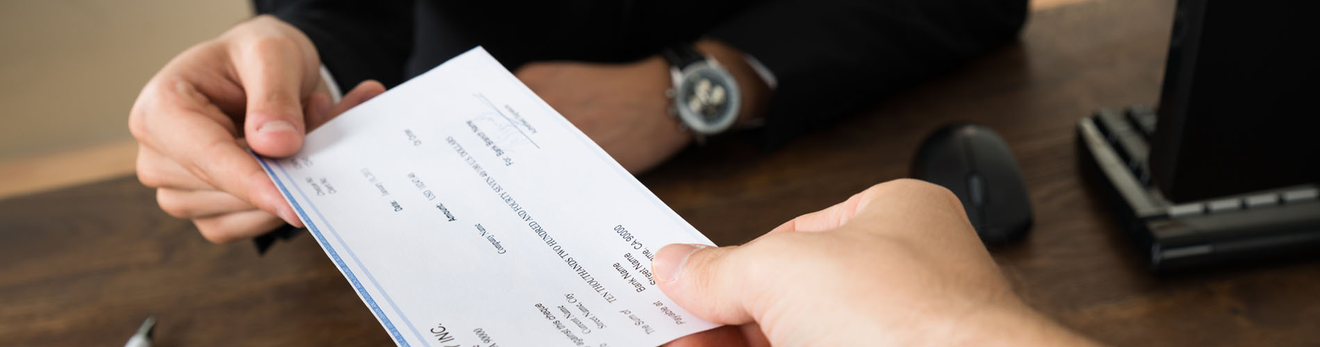 Unas manos muestran un cheque bancario