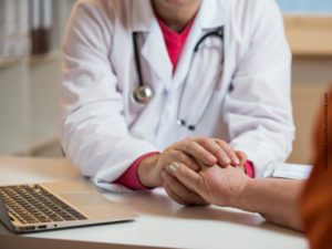 Manos del médico estrechando mano paciente mujer mayor