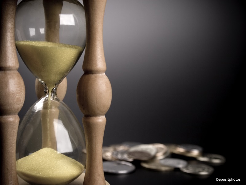Reloj de arena con monedas al fondo