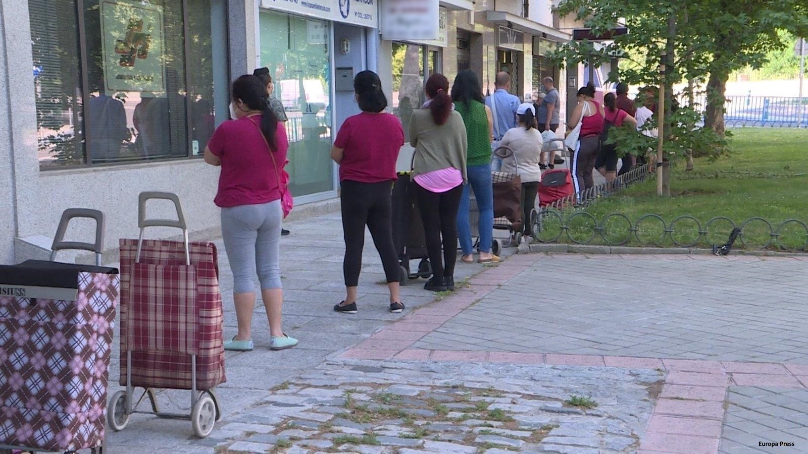 Personas a las puertas de un banco de alimentos
