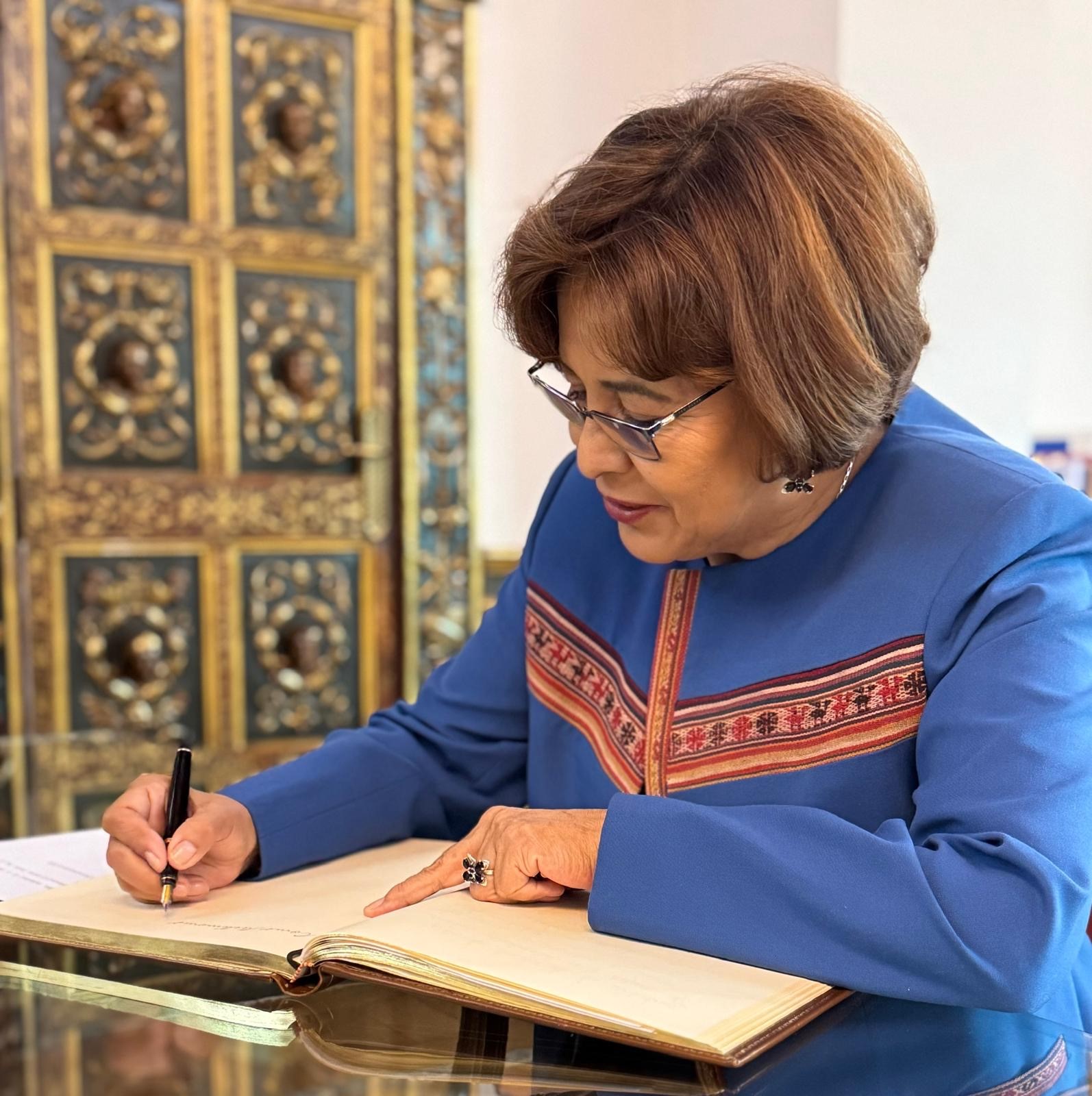 Nardi Suxo. embajadora de Bolivia, firmando en el despacho del Defensor